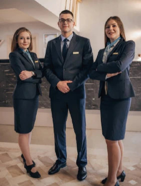 Tenue élégante pour réceptionniste - Conforme aux standards hôteliers Réceptionniste souriante en uniforme professionnel d’hôtel